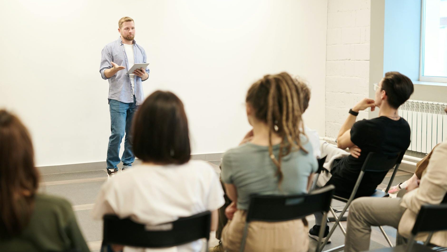 man wearing gray dress shirt and blue jeans